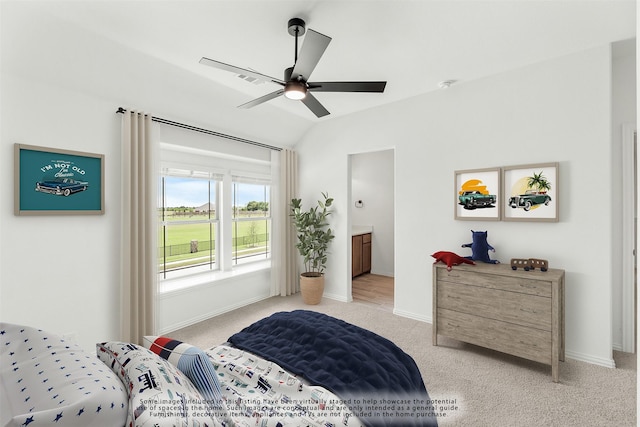 carpeted bedroom with ceiling fan, ensuite bath, and vaulted ceiling