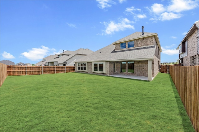 rear view of house featuring a lawn and a patio area