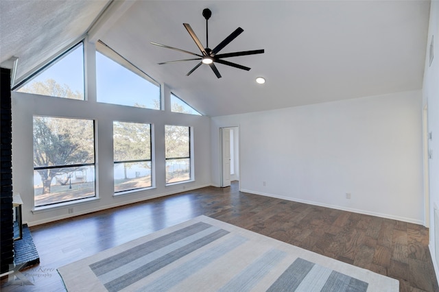 unfurnished living room with ceiling fan, lofted ceiling with beams, and dark hardwood / wood-style floors