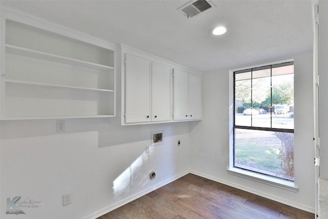 laundry area featuring electric dryer hookup, hookup for a washing machine, dark wood-type flooring, and cabinets