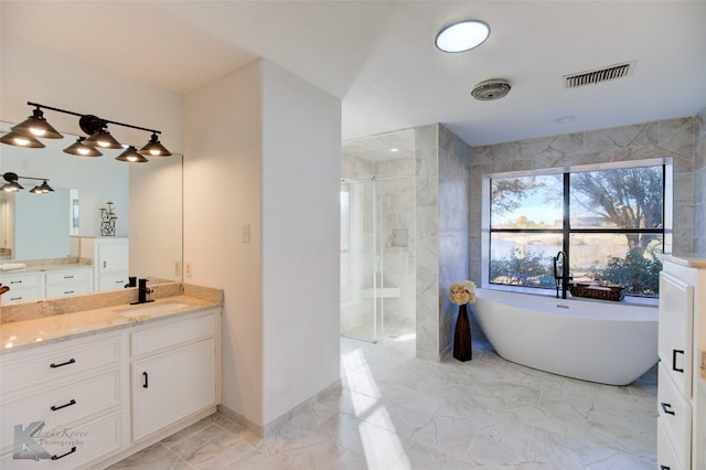 bathroom with independent shower and bath, vanity, and tile walls