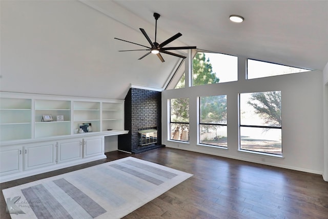 unfurnished living room with ceiling fan, high vaulted ceiling, dark wood-type flooring, and a fireplace