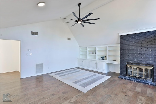 unfurnished living room featuring built in shelves, vaulted ceiling with beams, dark hardwood / wood-style flooring, ceiling fan, and a fireplace