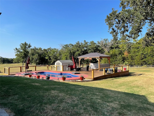 view of swimming pool featuring an outdoor structure, a fenced in pool, a gazebo, a storage shed, and a yard