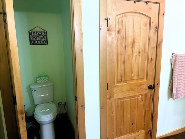 bathroom featuring baseboards and toilet