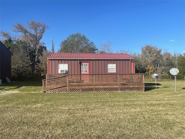 rear view of property featuring a yard, a deck, and metal roof