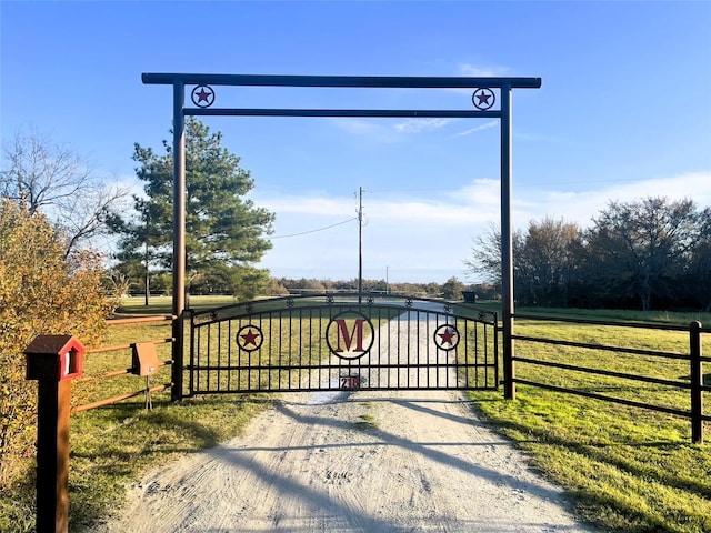 view of gate featuring a lawn and fence
