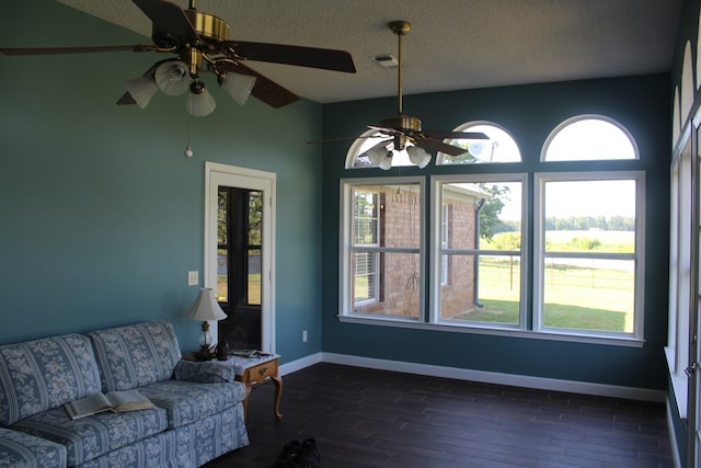 living room featuring dark hardwood / wood-style flooring, a textured ceiling, and ceiling fan