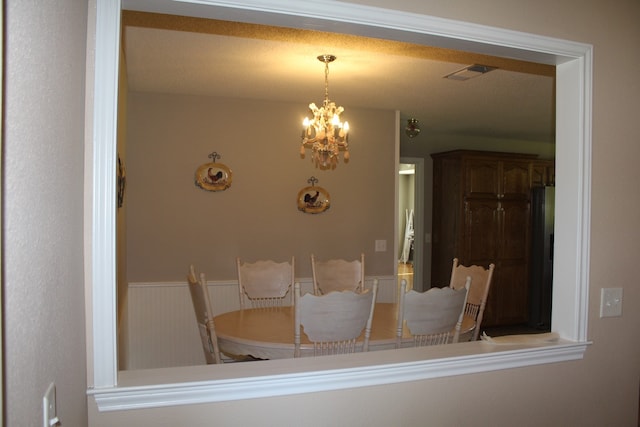 dining room with an inviting chandelier and a textured ceiling