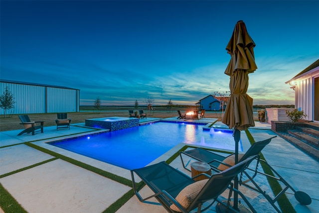 pool at dusk featuring an in ground hot tub, a patio, and pool water feature