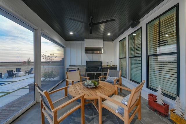 patio terrace at dusk with area for grilling and ceiling fan