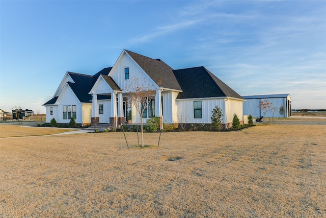 modern farmhouse featuring a front yard and covered porch