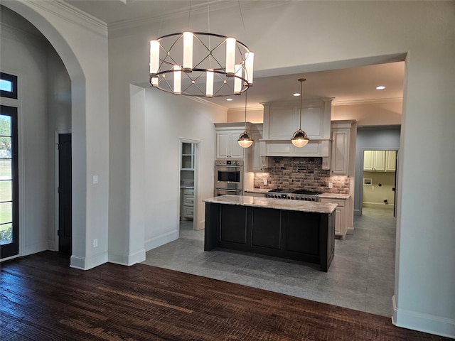 kitchen featuring a center island, dark hardwood / wood-style floors, tasteful backsplash, white cabinets, and hanging light fixtures