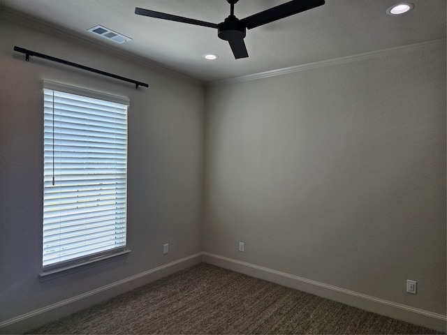 empty room featuring crown molding, dark colored carpet, and ceiling fan