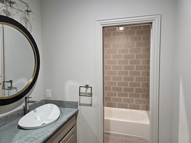 bathroom with tiled shower / bath and vanity