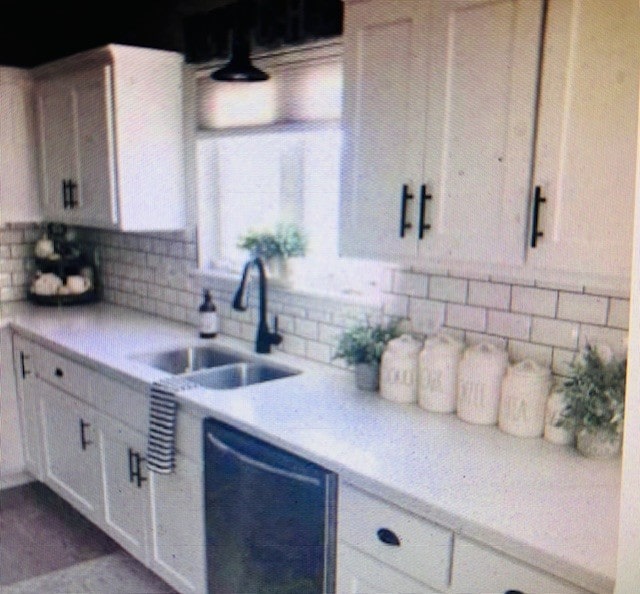 kitchen featuring sink, white cabinetry, backsplash, and dishwasher