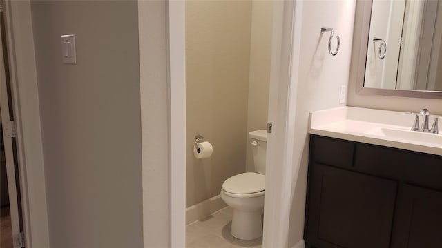 bathroom with toilet, tile patterned flooring, and vanity