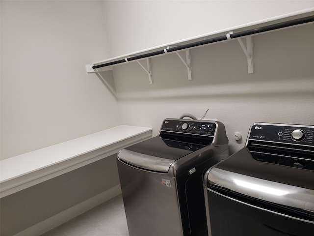 clothes washing area featuring washing machine and dryer and tile patterned flooring