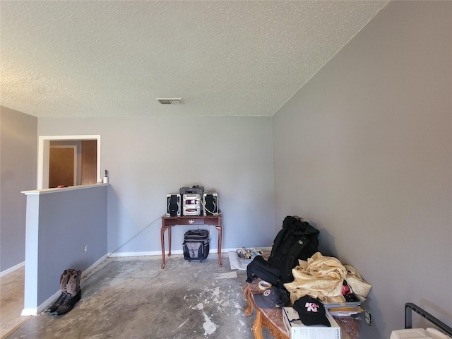 miscellaneous room with concrete flooring and a textured ceiling