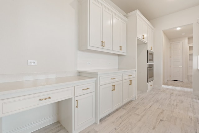 kitchen featuring appliances with stainless steel finishes, white cabinetry, and light hardwood / wood-style floors