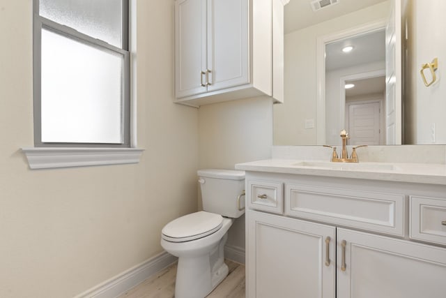 bathroom featuring hardwood / wood-style floors, oversized vanity, and toilet