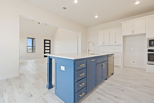 kitchen featuring an island with sink, light hardwood / wood-style flooring, white cabinetry, and sink