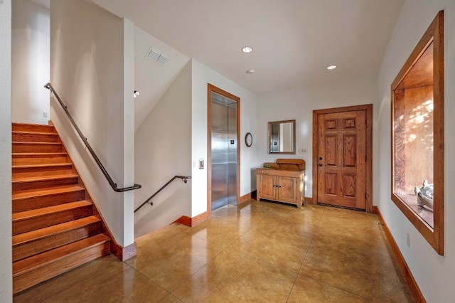 entrance foyer featuring elevator and light tile patterned floors