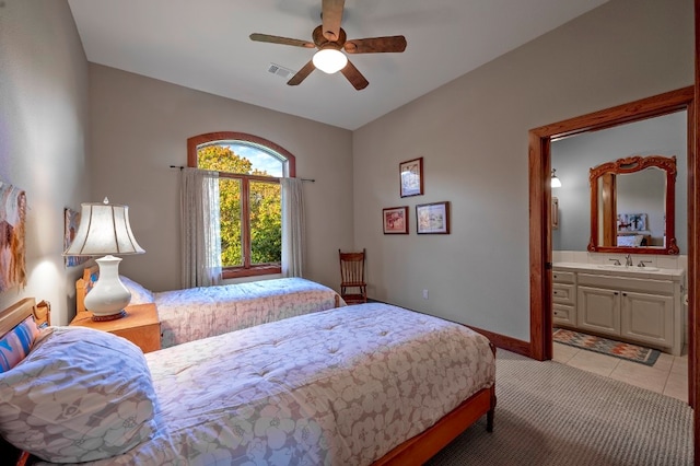 bedroom with ensuite bathroom, sink, light tile patterned floors, and ceiling fan