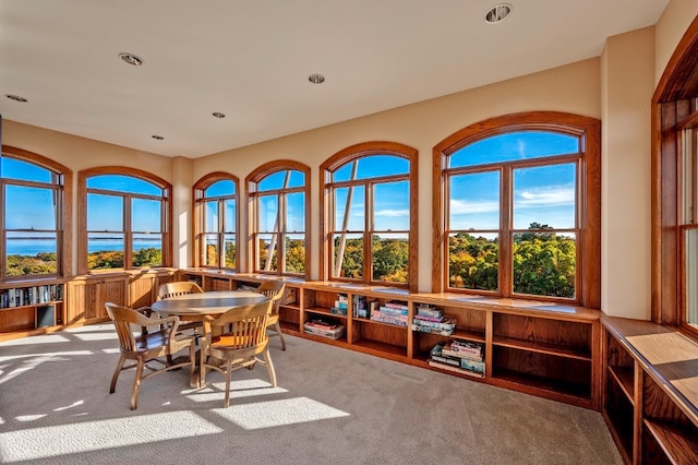 carpeted dining area with a water view