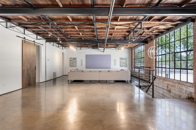 basement featuring a wealth of natural light, wooden ceiling, and a barn door