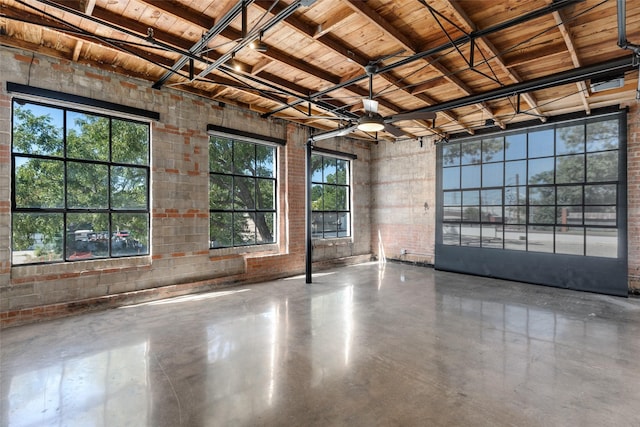 unfurnished room with wood ceiling and concrete flooring