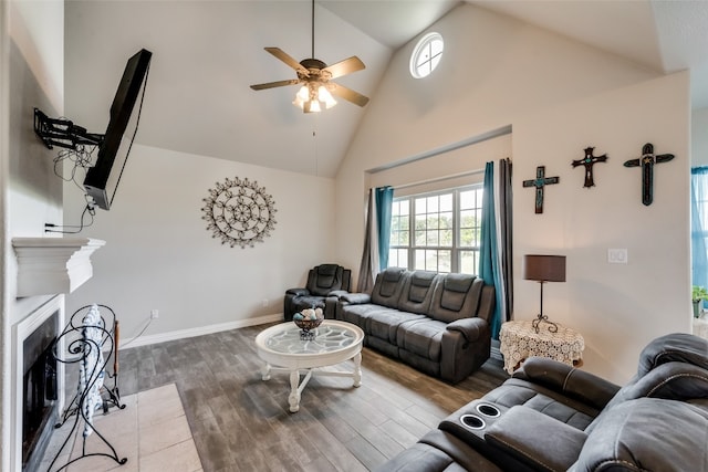 living room featuring wood-type flooring, ceiling fan, and high vaulted ceiling