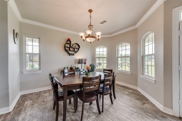 dining space featuring ornamental molding, light hardwood / wood-style flooring, and a chandelier