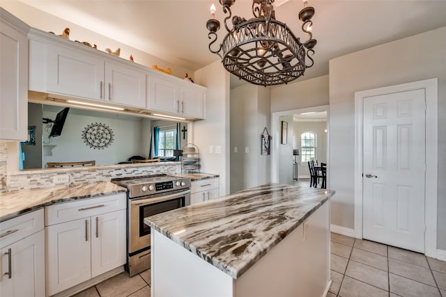 kitchen featuring stainless steel range with electric stovetop, a chandelier, white cabinetry, and a healthy amount of sunlight