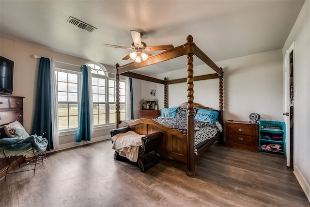 bedroom with dark hardwood / wood-style flooring and ceiling fan