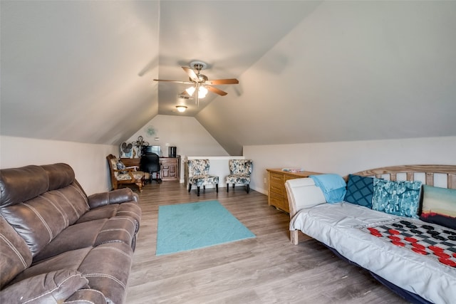 living room featuring ceiling fan, vaulted ceiling, and wood-type flooring