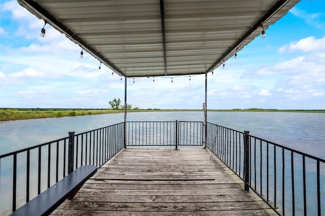 view of dock with a balcony and a water view