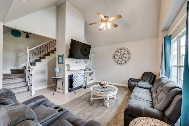 living room featuring high vaulted ceiling, light wood-type flooring, and ceiling fan