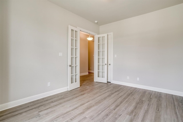 spare room with french doors and light hardwood / wood-style floors