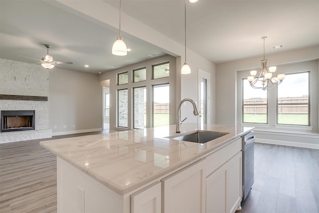 kitchen featuring sink, light hardwood / wood-style flooring, and a center island with sink