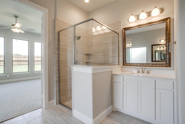 bathroom featuring tile patterned flooring, ceiling fan, vanity, and an enclosed shower