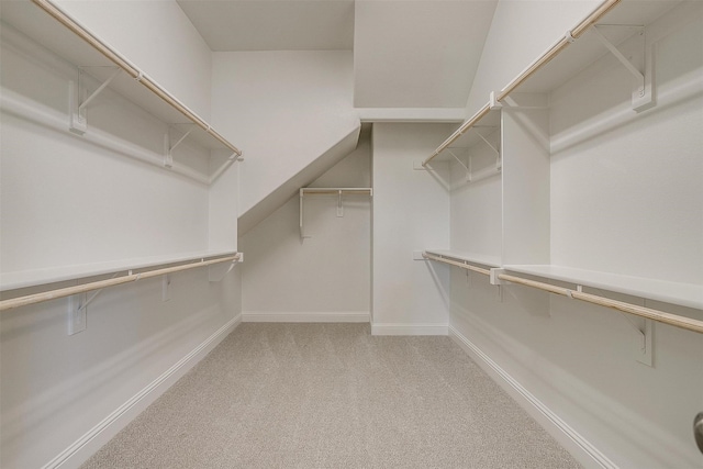 walk in closet featuring light colored carpet