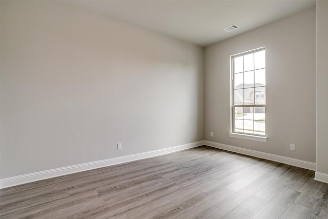 empty room featuring a healthy amount of sunlight and hardwood / wood-style floors