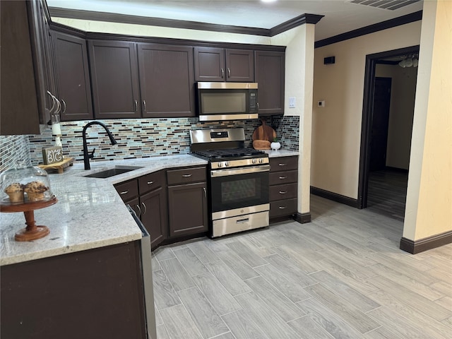 kitchen featuring dark brown cabinets, light stone counters, sink, and appliances with stainless steel finishes