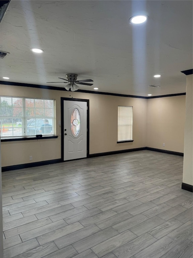 foyer with light hardwood / wood-style flooring, ceiling fan, and crown molding