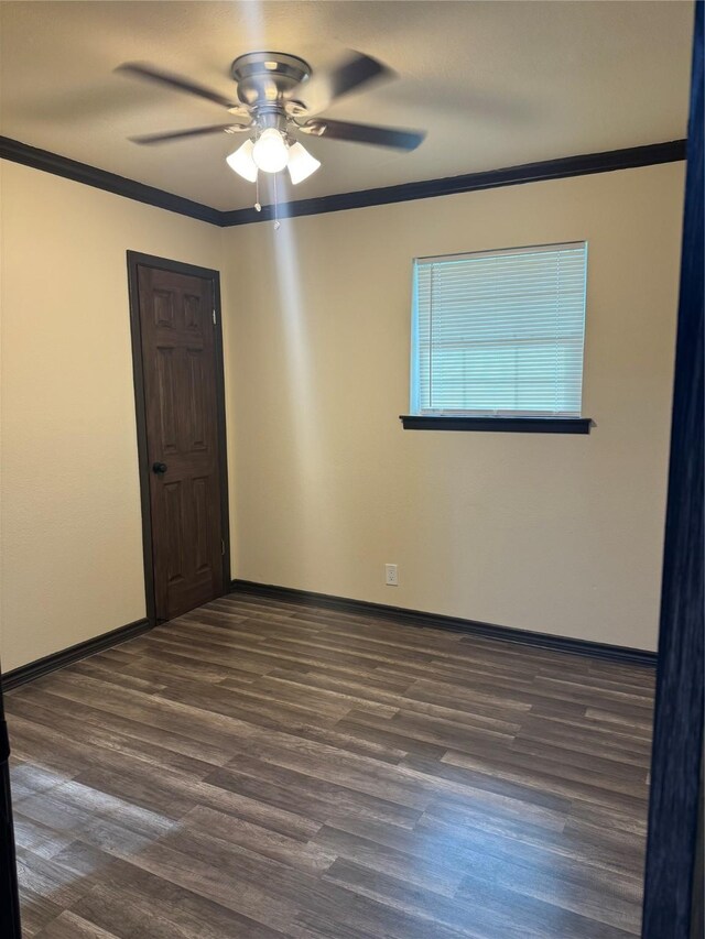 unfurnished room with ornamental molding, ceiling fan, and dark wood-type flooring