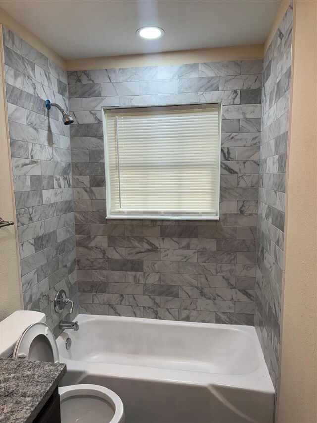 full bathroom featuring vanity, toilet, and tiled shower / bath