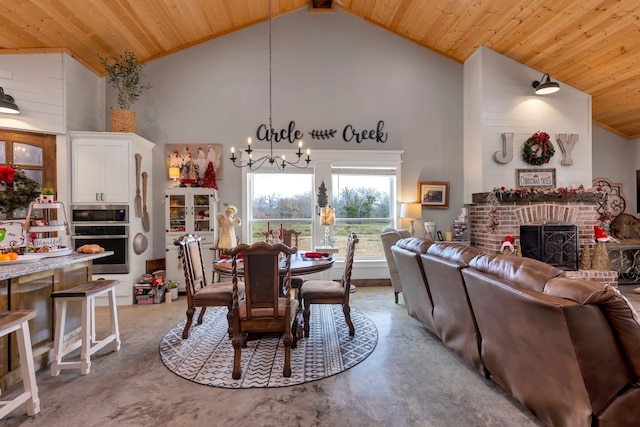 dining space featuring a brick fireplace, a notable chandelier, high vaulted ceiling, and wooden ceiling