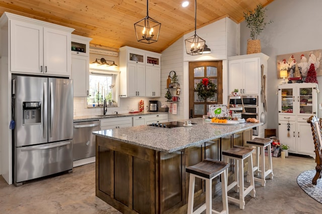 kitchen with appliances with stainless steel finishes, hanging light fixtures, wood ceiling, and a kitchen island