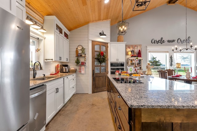 kitchen with a kitchen island, stainless steel appliances, white cabinets, sink, and decorative light fixtures